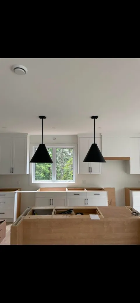 Black cone pendants installed over a kitchen island in a new build