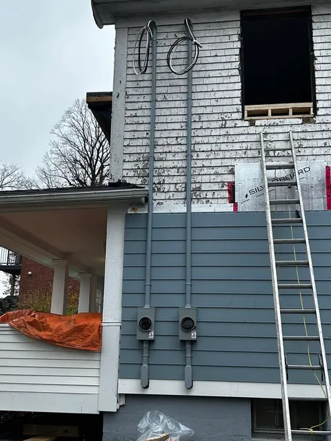 Twin service masts and conduit roughed in during a renovation