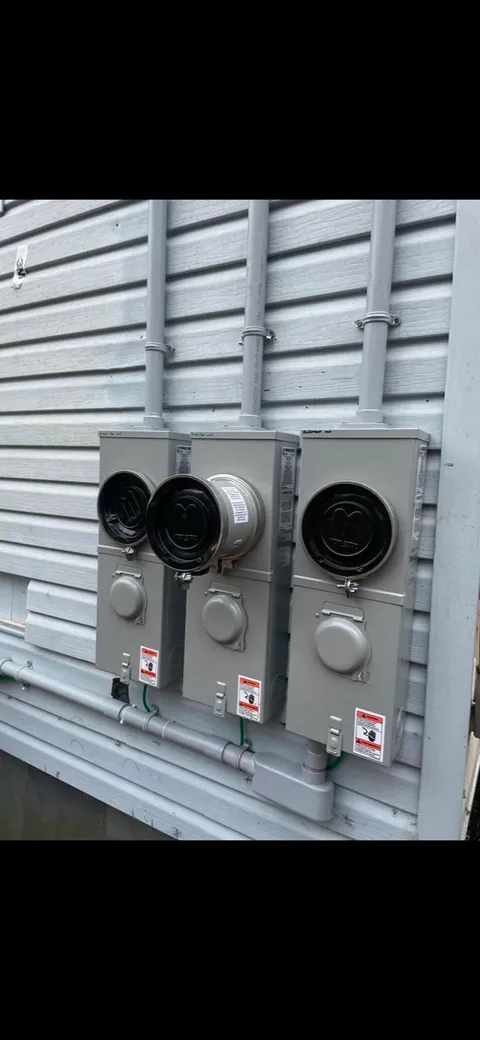 Three meter bases installed in a row on a multi-unit building